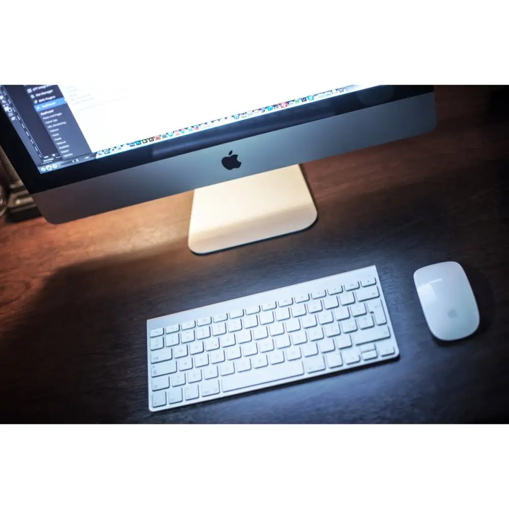 Stříbrný apple imac 12.2 27 palců s bílou klávesnicí a myší na tmavém dřevěném stole výkonný stolní počítač s čtyřjádrovým výkonem