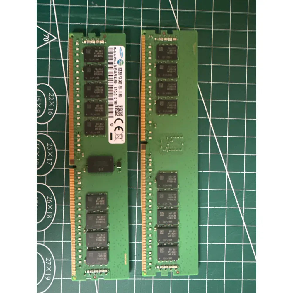 Dva zelené paměťové moduly samsung ram s černými čipy a zlatými kontakty na řezačce paměť sk hynix 16gb ddr4-2400 ecc rdimm 2rx4