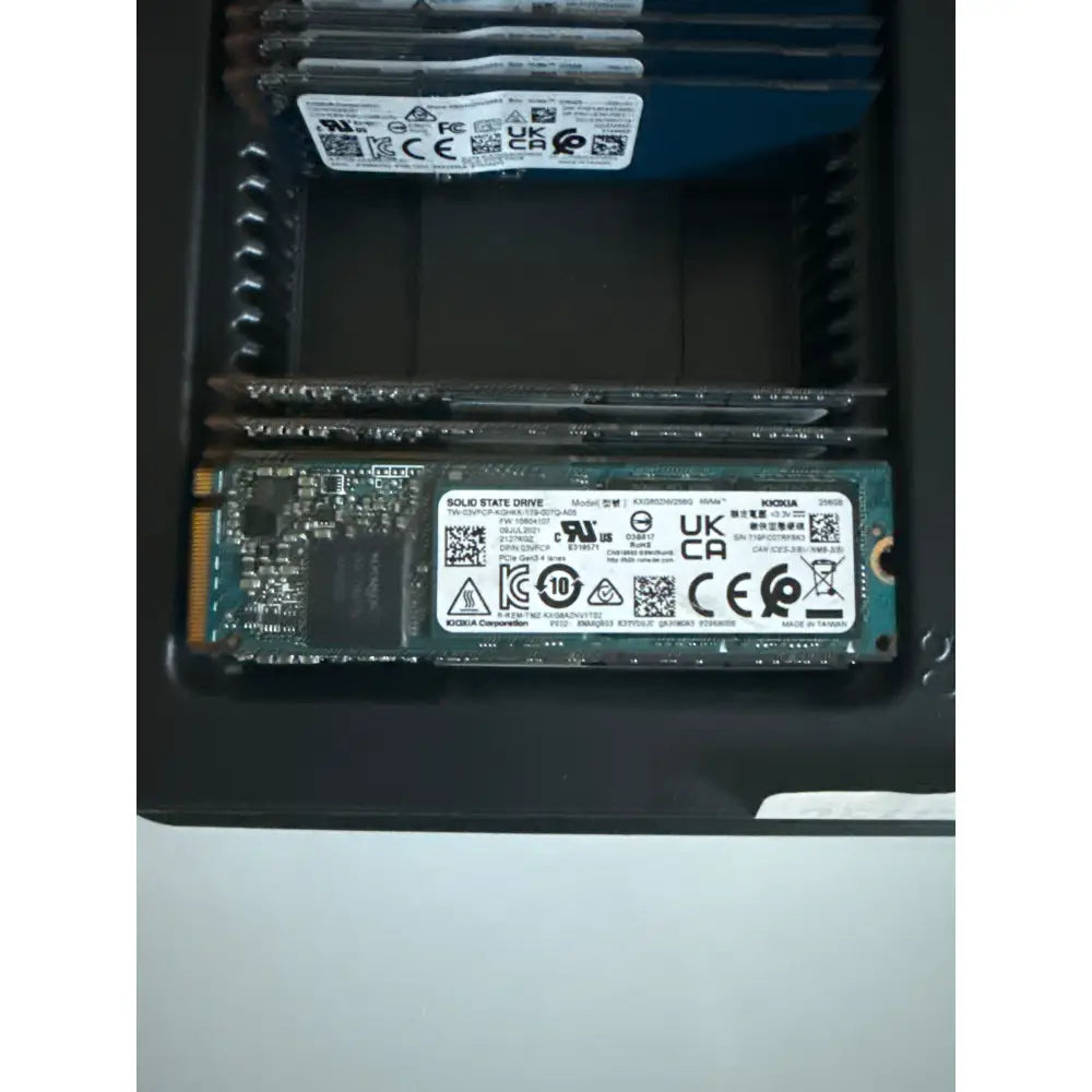 Černozelený nvme ssd kingston s bílou nálepkou a certifikačními logy, 256gb m.2 pcie 3.0 x4, model kioxia toshiba xg6