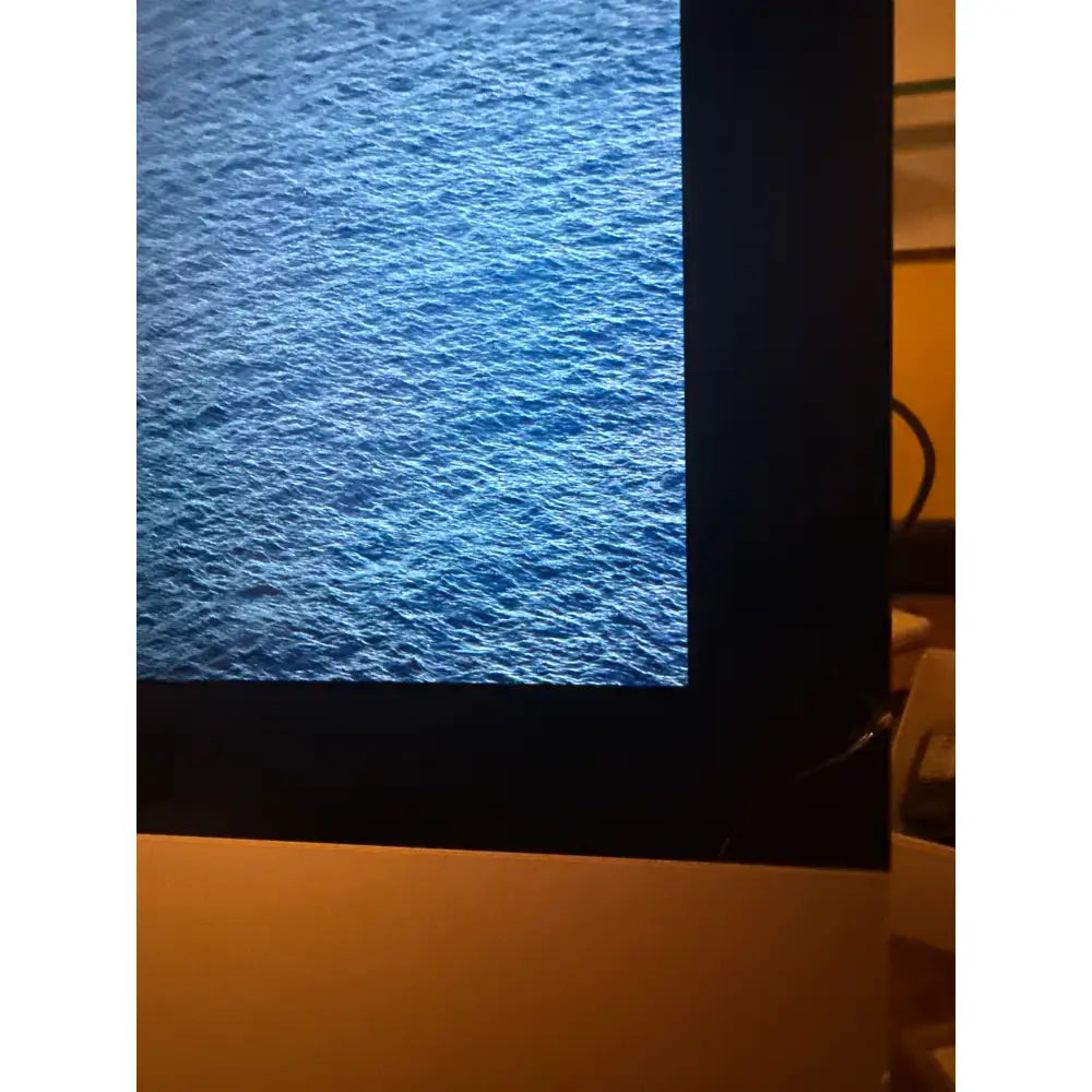 Apple iMac 17.1 2015 27 palců 5K s černým rámem a jasnou modrou tapetou oceánu na obrazovce